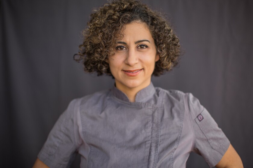 A portrait of a woman in a chef's coat.
