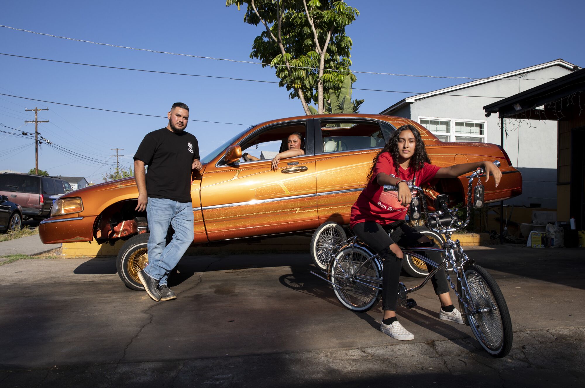 From left, Saul Razo, 31, DeAnna Garcia, 48, and Trinity Padilla, 13, pose with a 2000 Lincoln Town Car.