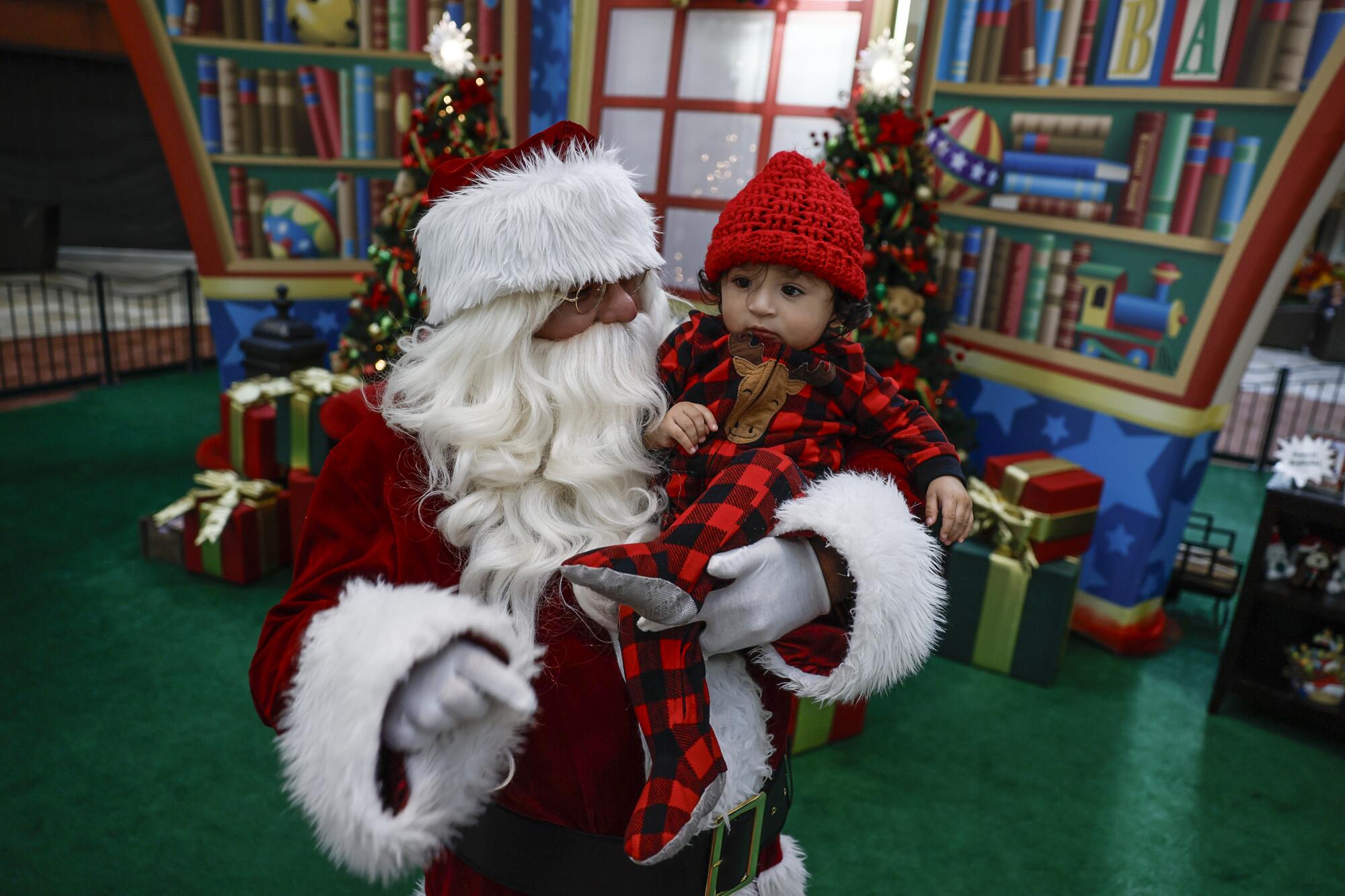 Adan Gonzalez, 11 months, is held by Santa.
