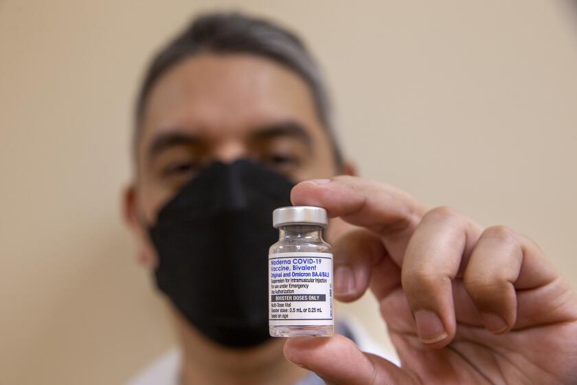 SOUTHGATE, CA-OCTOBER 6, 2022: Daniel Carrillo, a pharmacist at AltaMed in Southgate, holds a bottle containing booster doses of the Moderna COVID-19 vaccine, Bivalent, the updated booster from Moderna designed to help protect against multiple COVID-19 variants in a single shot. Earlier he administered this vaccine to Senator Alex Padilla. (Mel Melcon / Los Angeles Times)