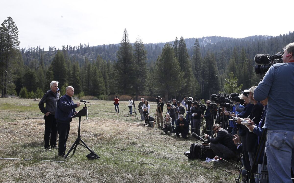 Gov. Jerry Brown announces mandatory drought restrictions while standing in a snowless Sierra Nevada meadow on April 1.