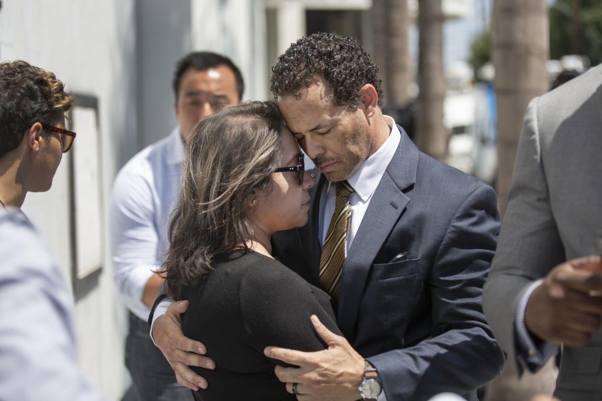 Pilar Looney, left, and Benson Williams comfort each other at a news conference Thursday outside the Orange County district attorney's office. A Fullerton police officer fatally shot their daughter Hannah Williams, 17, last week on the 91 Freeway.