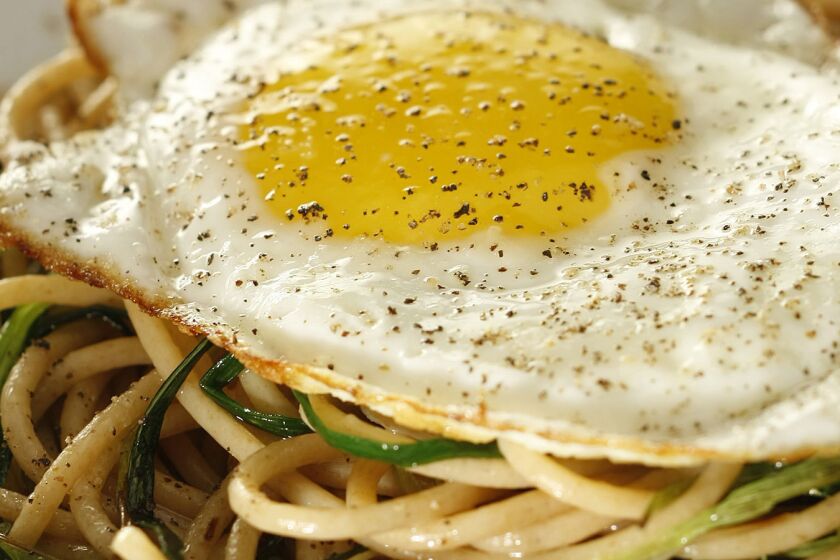 Whole wheat spaghetti with green garlic and fried egg.