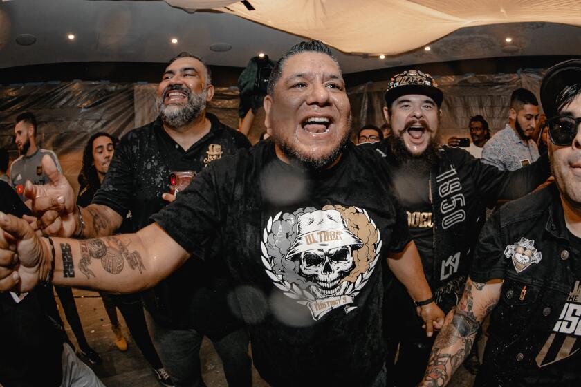 The 3252 vice president Mo Fascio, center, celebrates after presenting the 2019 Supporter's Shied to LAFC players.