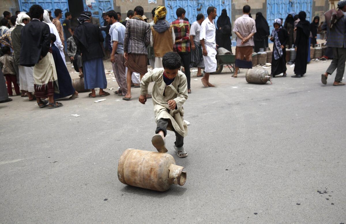 A boy rolls a canister of gas he bought on Aug. 18 after waiting for hours in Sana, Yemen, where ongoing fighting has caused widespread shortages.