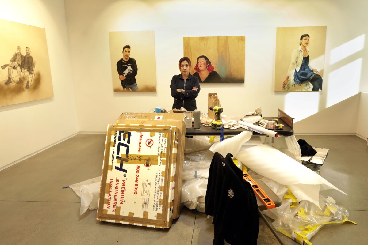 Shizu Saldamando stands amid boxes of art at Oxy Arts.