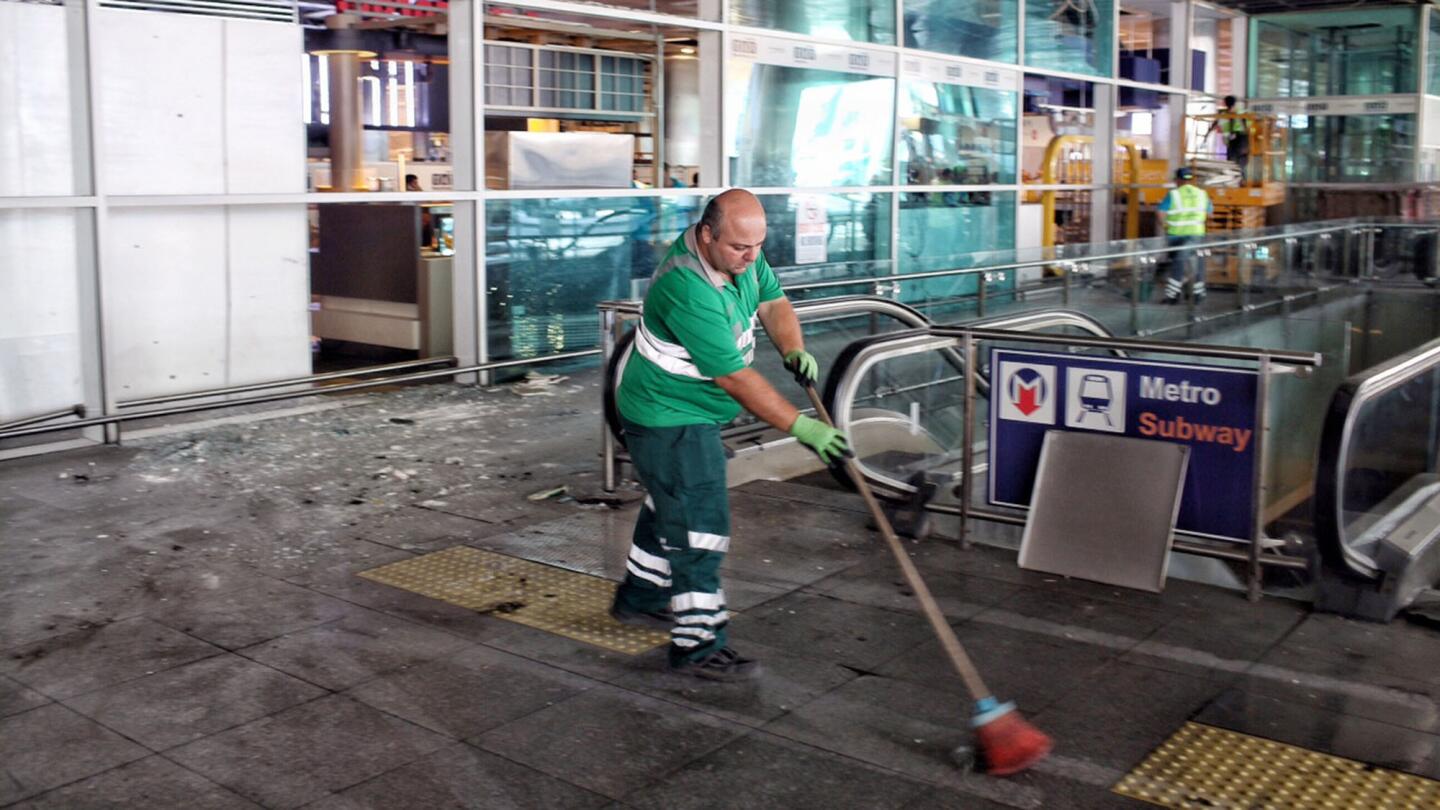 Workers clean the debris from Tuesday's attack at Turkey's largest airport on Wednesday.