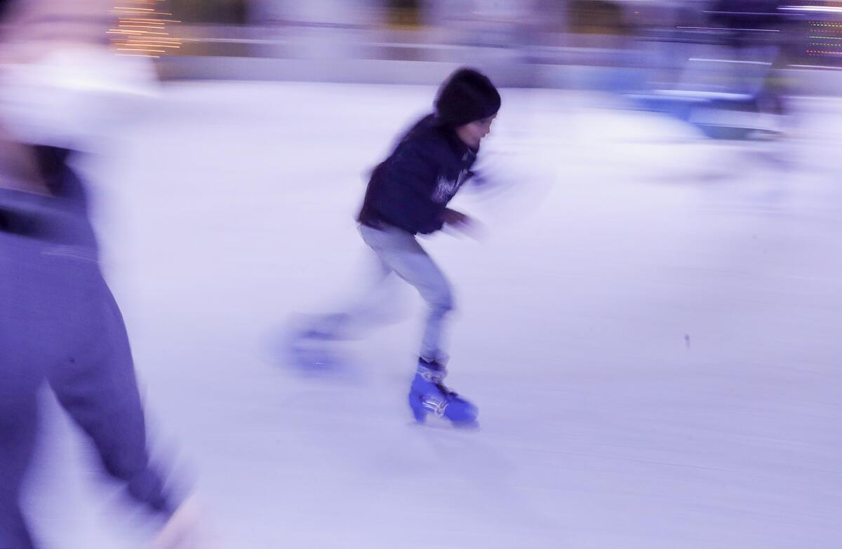 A skater picks up speed at the Santa Ana Winter Village skating rink in downtown Santa Ana.