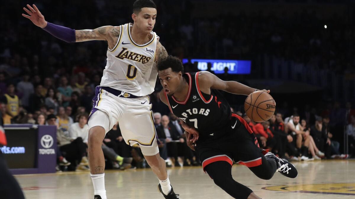 The Toronto Raptors' Kyle Lowry dribbles next to Lakers' Kyle Kuzma during the second half on Nov. 4. The Lakers suffered a lopsided 121-107 loss to the Raptors.