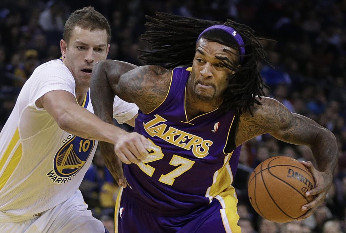 Lakers center Jordan Hill, right, drives past Golden State Warriors forward David Lee during the first half of Saturday's game.