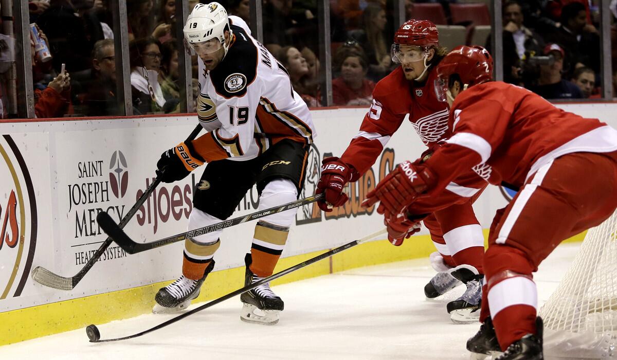 Ducks left wing Patrick Maroon (19) draws the attention of Red Wings defensemen Danny DeKeyser, center, and Brendan Smith in the first period Saturday night in Detroit.