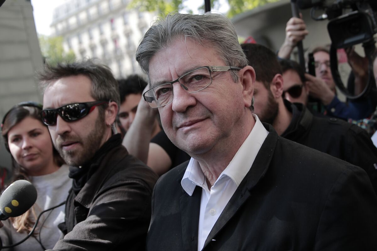 French far-left party leader and former candidate for the presidential election Jean-Luc Melenchon arrives, surrounded by medias, during a May Day demonstration march from Republique, Bastille to Nation, in Paris, France, Sunday, May 1, 2022. Citizens and trade unions in France take to the streets to put out protest messages to their governments as a rallying cry against newly reelected President Emmanuel Macron. (AP Photo/Lewis Joly)