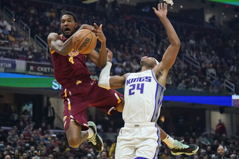 Cleveland Cavaliers' Evan Mobley (4) tries to grab a pass next to Sacramento Kings' Buddy Hield (24) during the first half of an NBA basketball game Saturday, Dec. 11, 2021, in Cleveland. (AP Photo/Tony Dejak)
