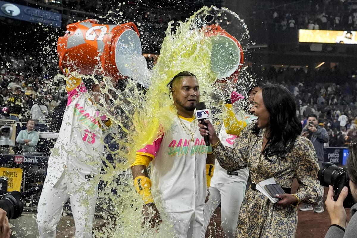 San Diego's Luis Arráez is doused by teammates Manny Machado, left, and Fernando Tatis Jr. 