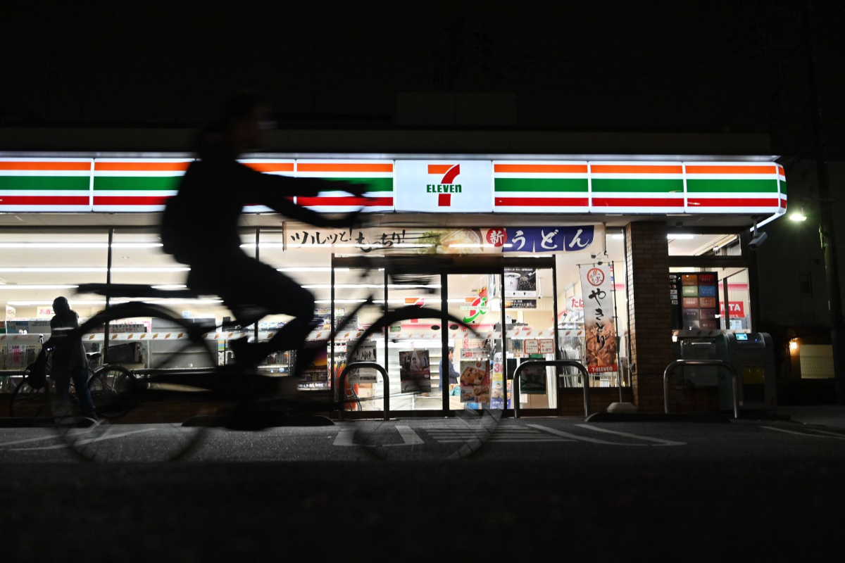 This photo taken on April 21, 2019 shows a cyclist passing a 7-Eleven.