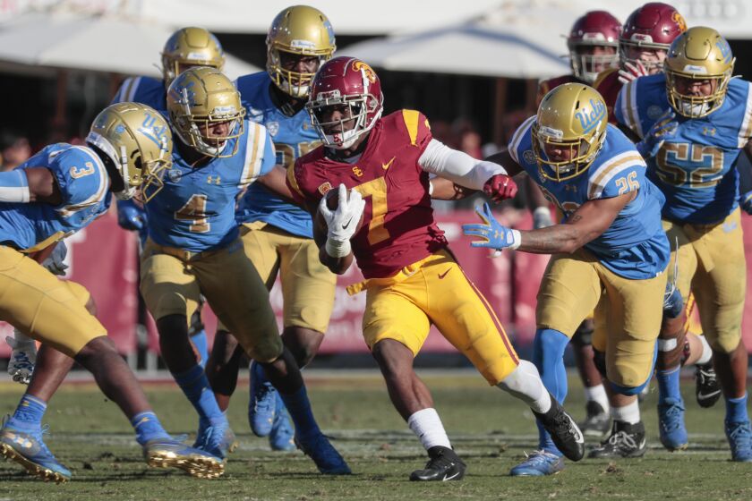 LOS ANGELES, CA, SATURDAY, NOVEMBER 23, 2019 - USC Trojans running back Stephen Carr (7) runs past Bruins defenders during a second half drive at the Coliseum. (Robert Gauthier/Los Angeles Times)