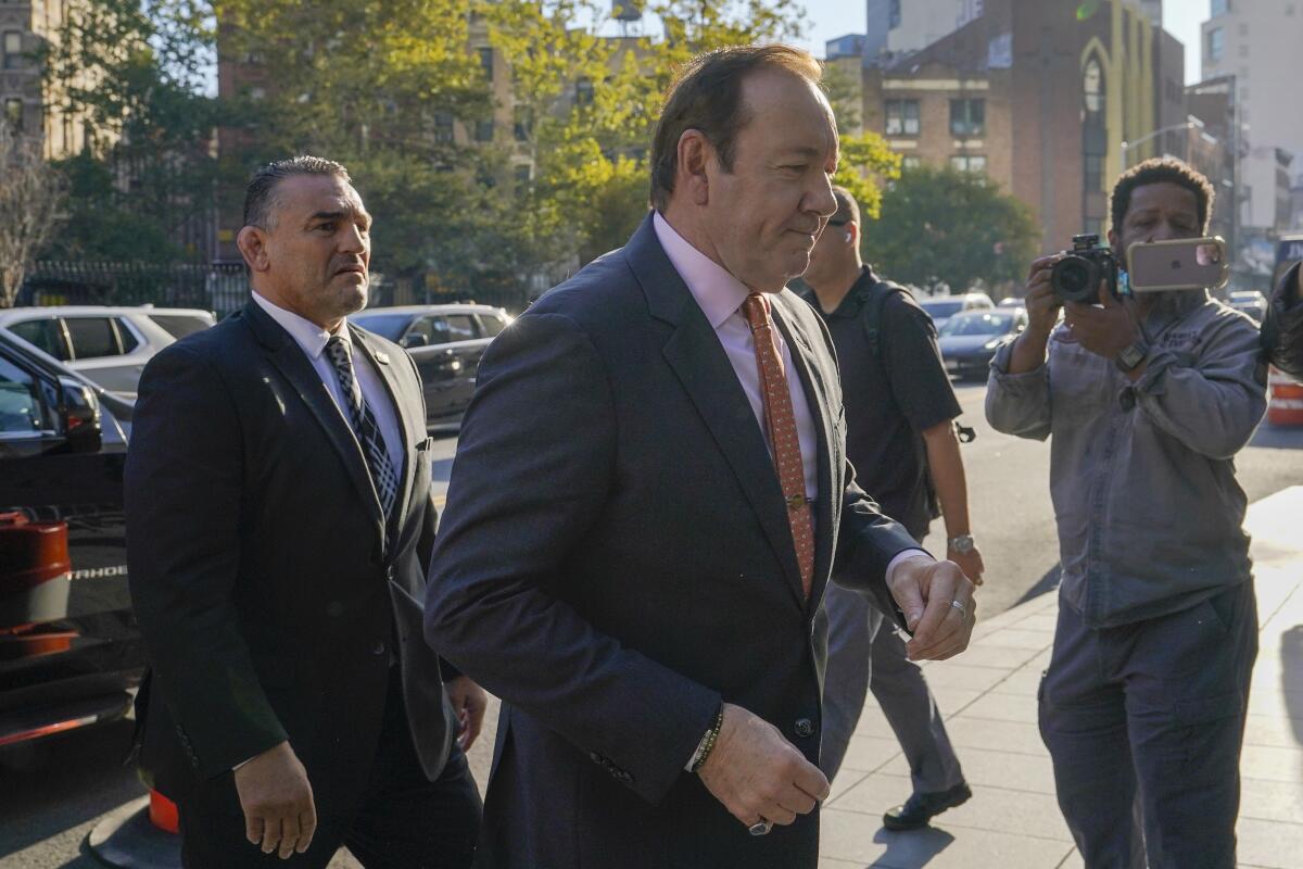 Men in suits walking on a sidewalk