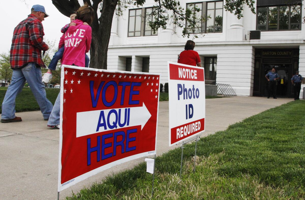 People following a sign that says "Vote aqui here"
