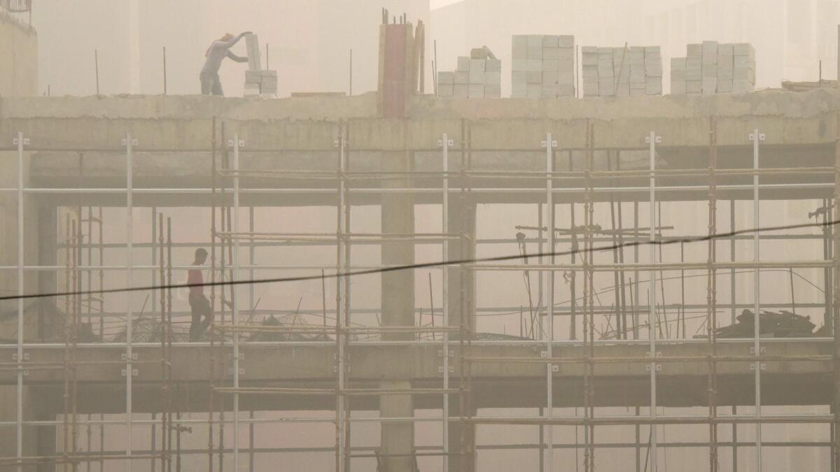 Indian laborers work on a construction site in New Delhi.