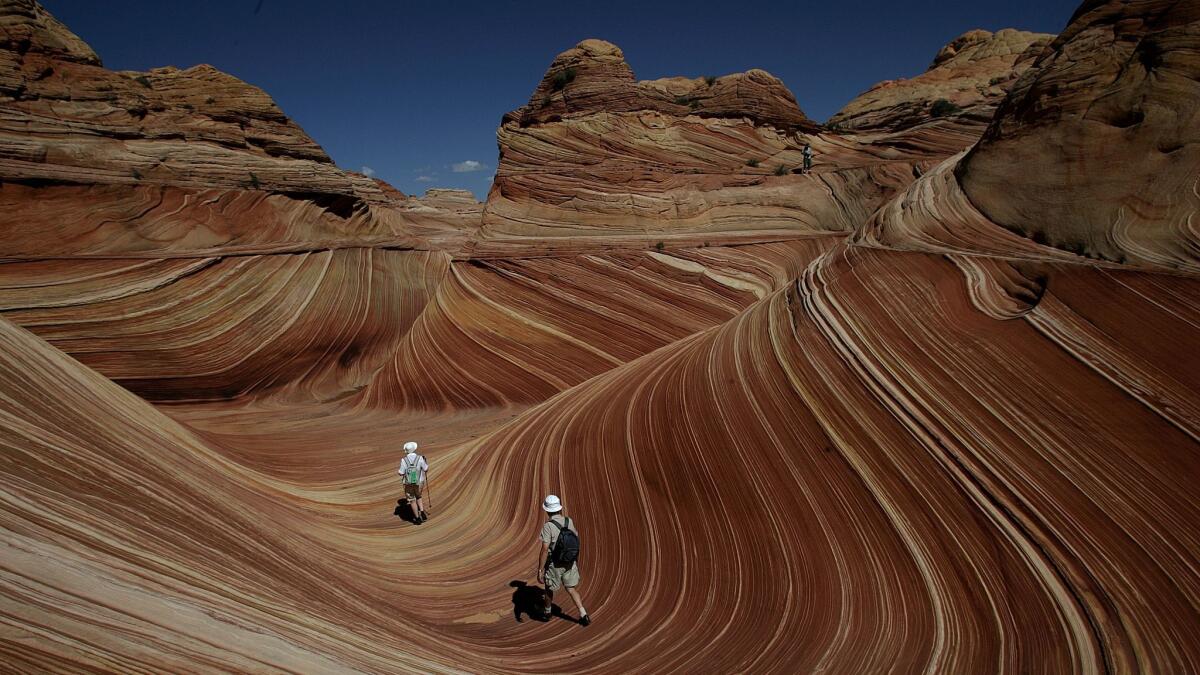 Weiner, Spencer   Hikers among the rock formations at "the Wave" in the Coyote Buttes area of the Paria CanyonVermillion Cliffs Wilderness on the Utah/Arizona border. Paria CanyonVermillion Cliffs Wilderness, Sept. 13, 2007. The Vermillion Cliffs Wilderness, near Page, Arizona is home to canyons and amazing rock formations. The area is so sensitive that the park service only allows a total of 20 people in the park per day. Permits are given through a lottery.