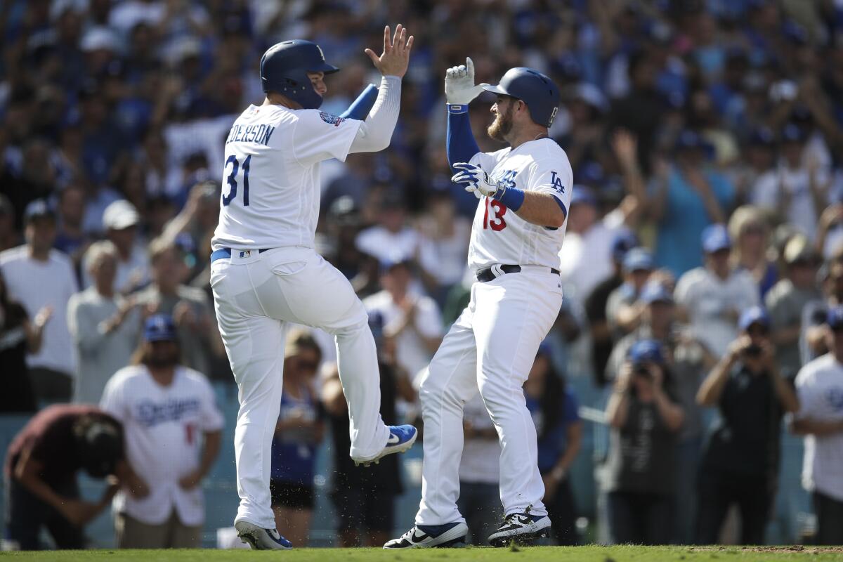 Max Muncy celebrates with Joc Pederson after hitting a two-run home run against the Colorado Rockies.
