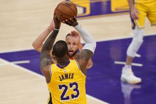 The Lakers' LeBron James shoots over the Warriors' Stephen Curry for the winning three-pointer May 19, 2021.