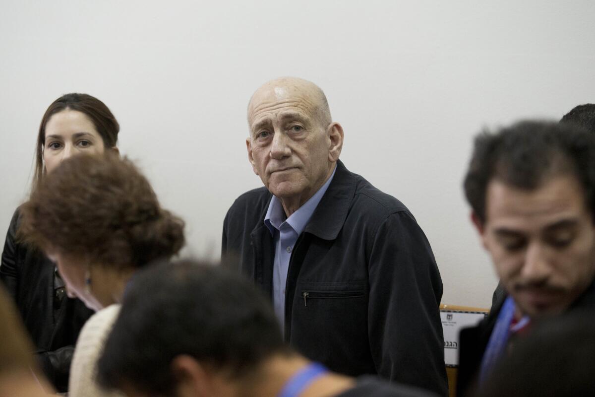 Former Israeli Prime Minister Ehud Olmert, center, waits for a hearing in Jerusalem's District Court on March 30.