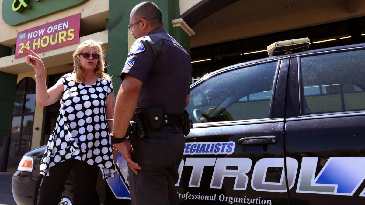 Bonnie Bernard, owner of Flowers 4-U, talks with a private security officer about the homeless situation at a Sylmar shopping center in 2015.