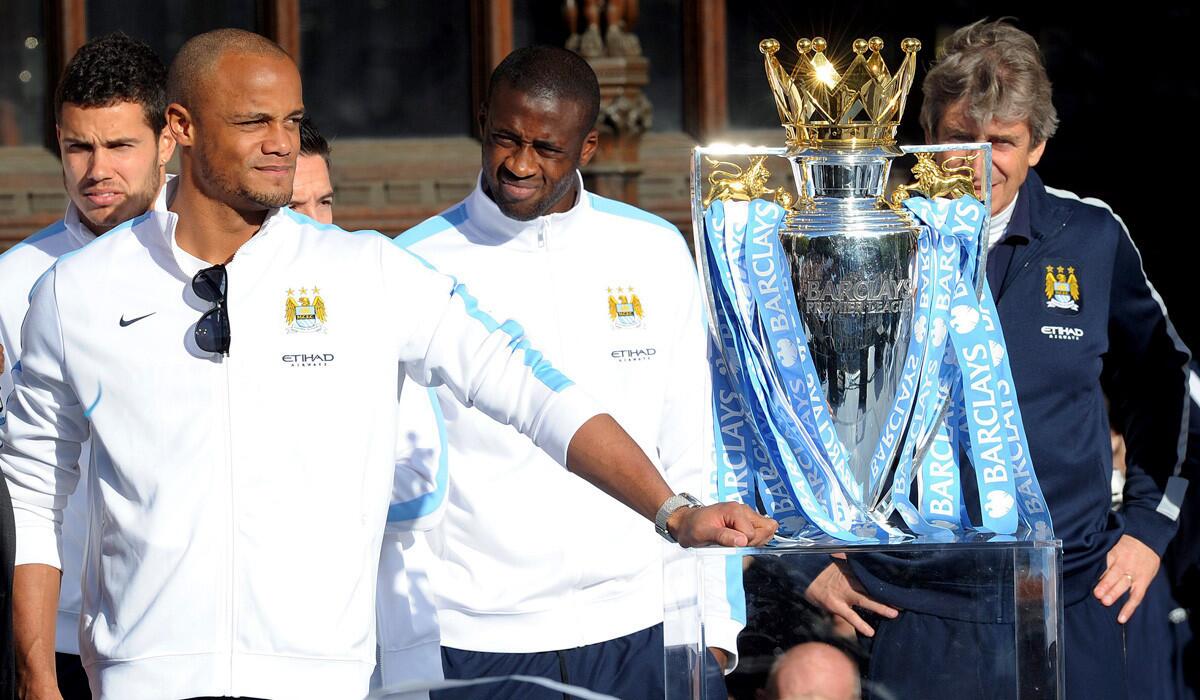 Manchester City captain Vincent Kompany joins teammates and Manager Manuel Pelegrino, right, during a celebration of their Premier League championship at City Hall on Monday.