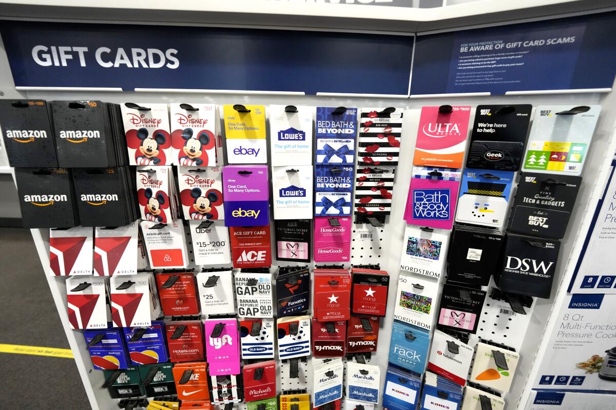 Gift cards hang on a display at a store. 