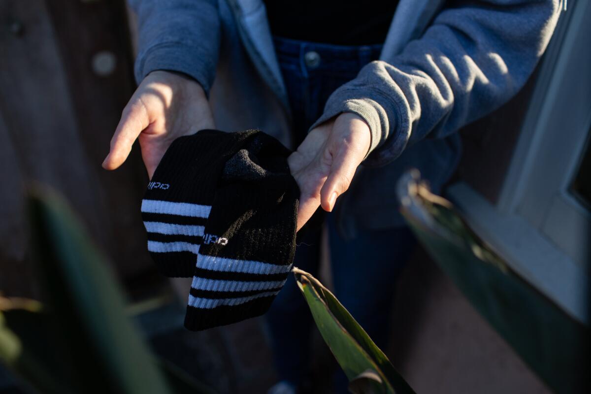 Grace Campbell-McGuire holds socks left behind by the robber