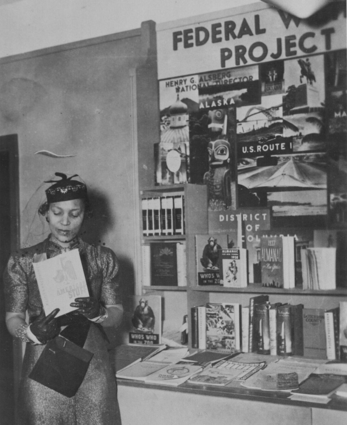 Zora Neale Hurston stands beside books sitting on bookshelves