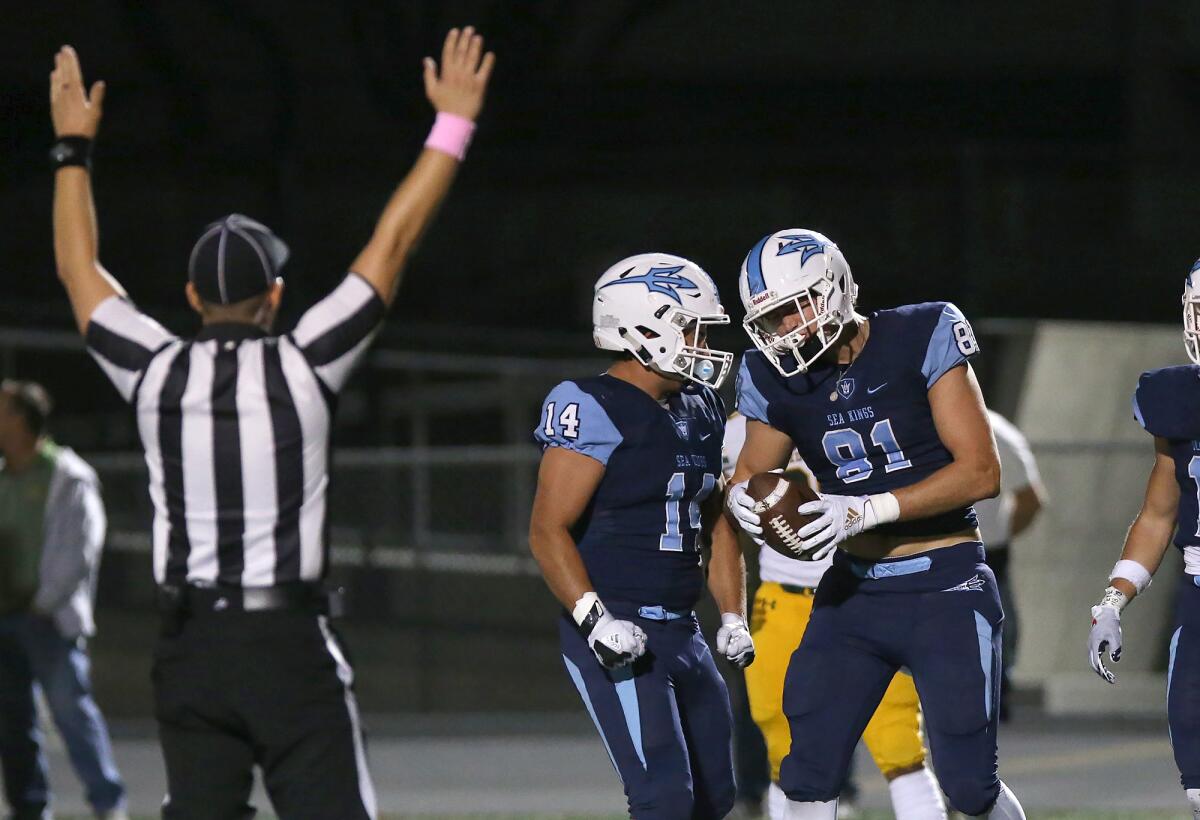 Corona del Mar's Max Farzine (14) congratulates Mark Redman for catching a 15-yard touchdown pass against Edison in a Sunset League game on Oct. 11 at Newport Harbor High.