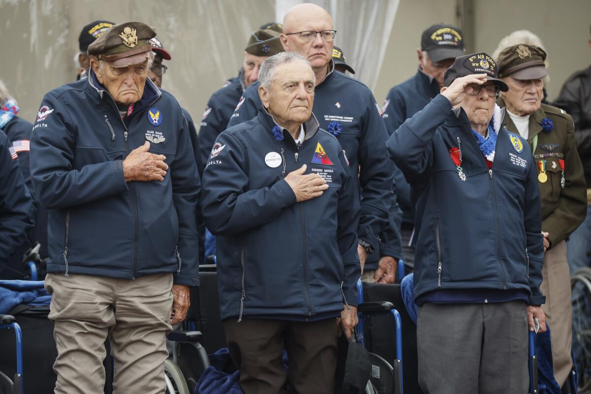 U.S. veterans saluting during D-day commemoration ceremony