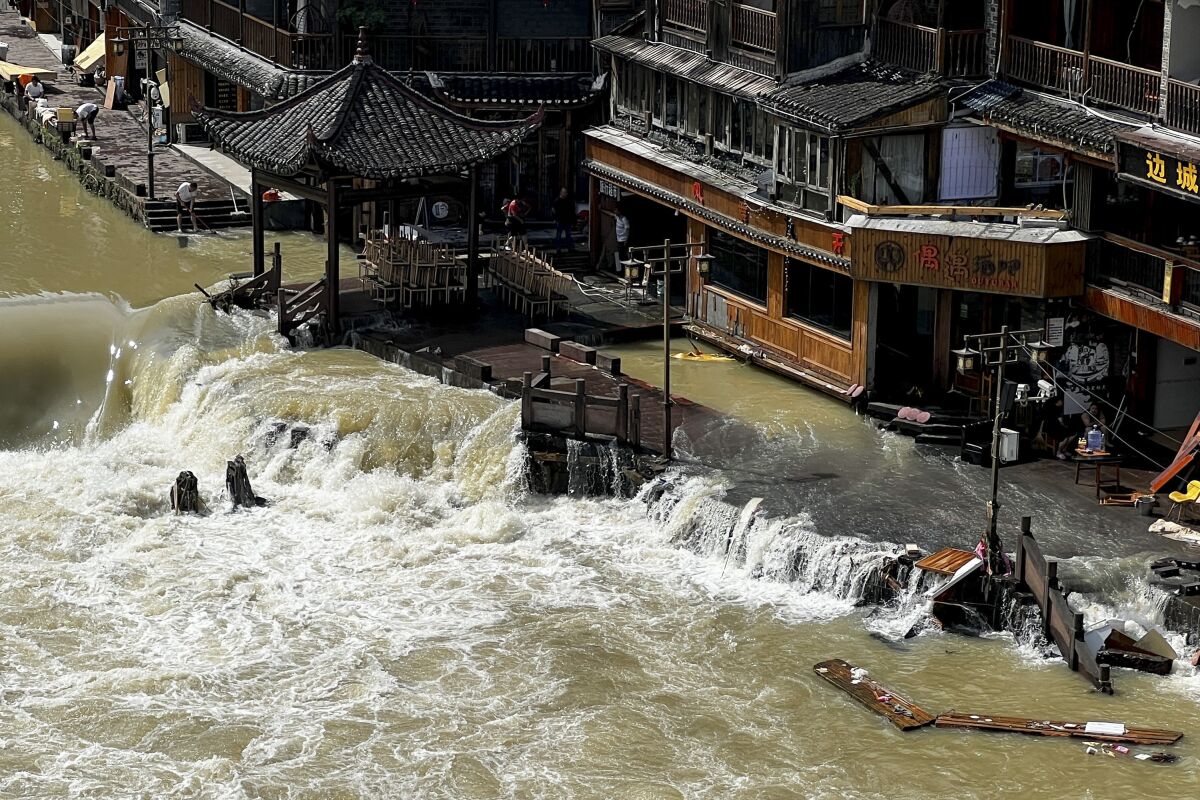 CORRECTS TOWN - Flood waters sweep through the ancient town of Feng Huang in central China's Hunan province, Saturday, June 4, 2022. State media reported some deaths and missing in flooding in the province. (AP Photo)