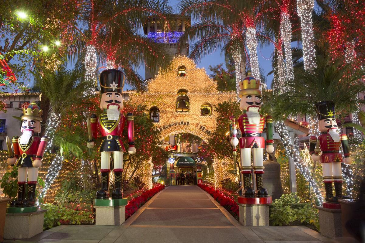 Mission Inn and palm trees decorated with lights and giant nutcracker soldiers.