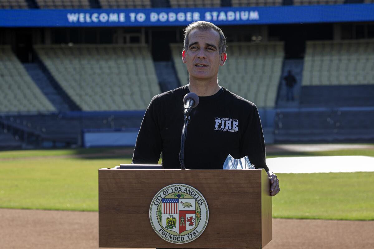 L.A. Mayor Eric Garcetti addresses a news conference at the launch of COVID-19 vaccination site at Dodger Stadium.