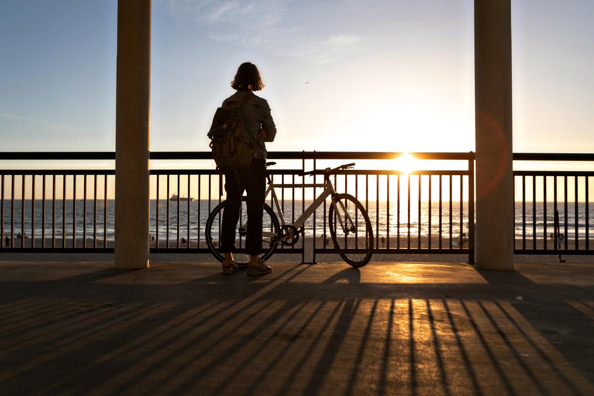 A man watches the sun set at Dockweiler State Beach in Playa del Rey on March 13