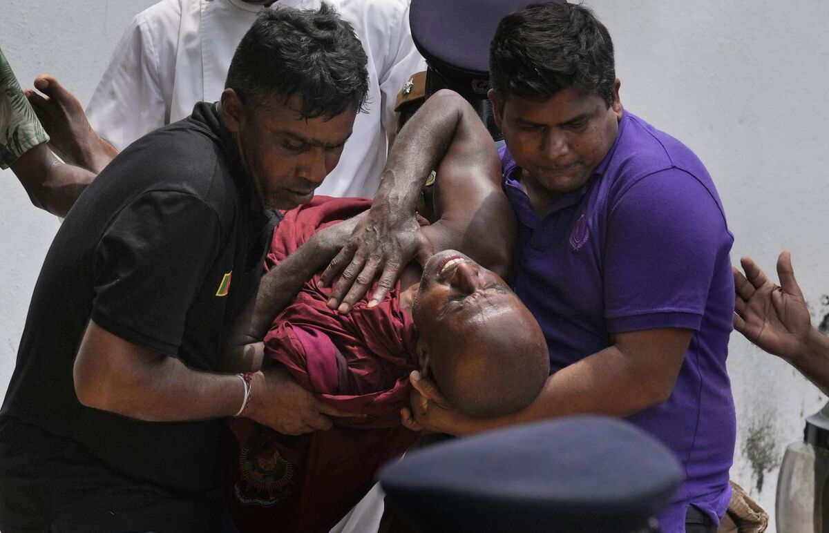 Injured Buddhist monk being carried away from protest in Sri Lanka