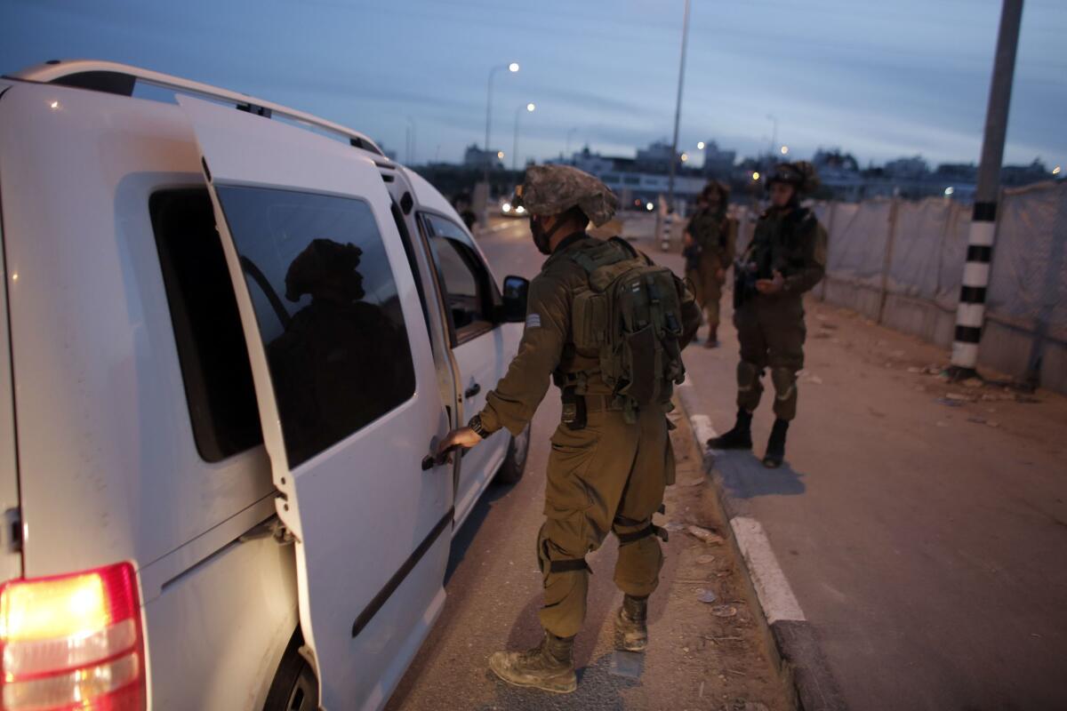 Israeli soldiers inspect cars at a checkpoint in the village of Beit Einun near the settlement of Kiryat Arba on April 2 after reports that an Israeli has gone missing.