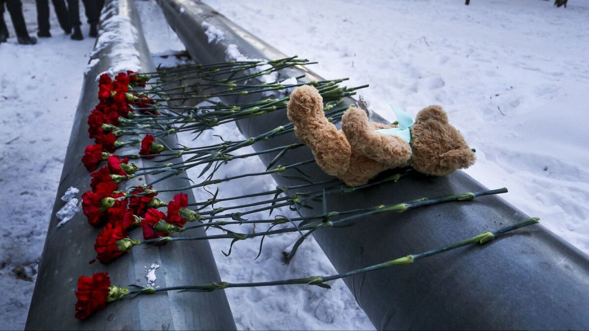A teddy bear and flowers lie at the scene of a collapsed apartment building in Magnitogorsk, Russia.
