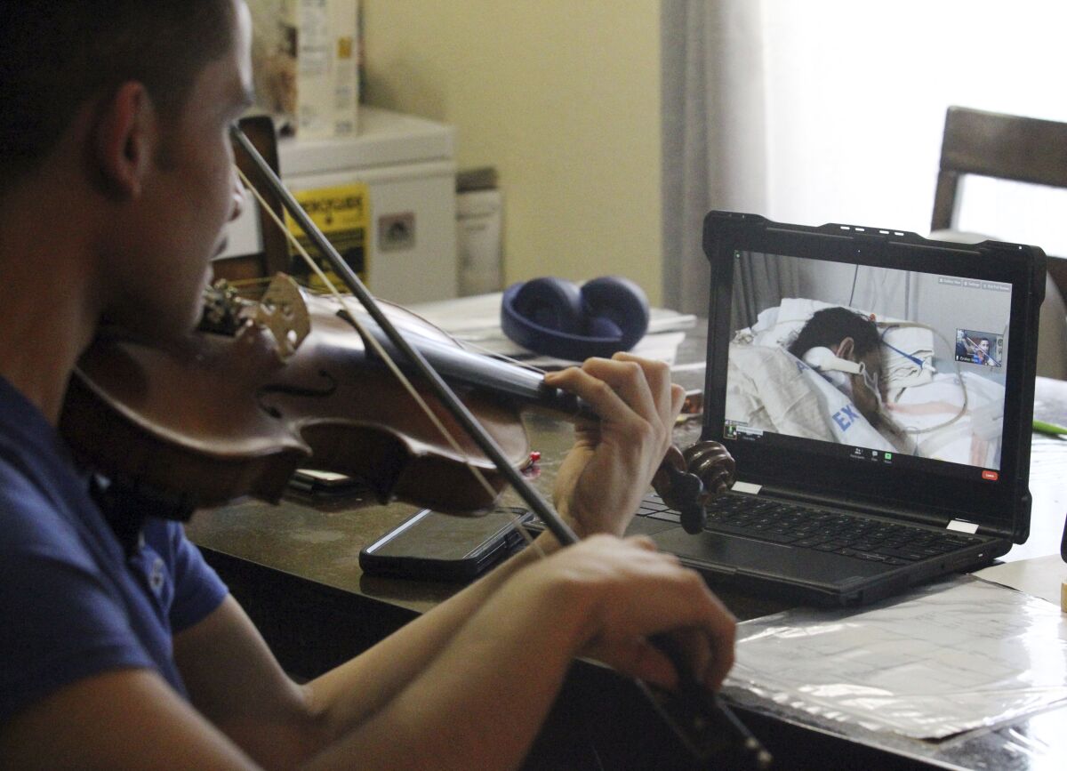 Emilian Sosa, 14, plays the violin for his mother, who is battling COVID-19 in a hospital in McAllen, Texas. 