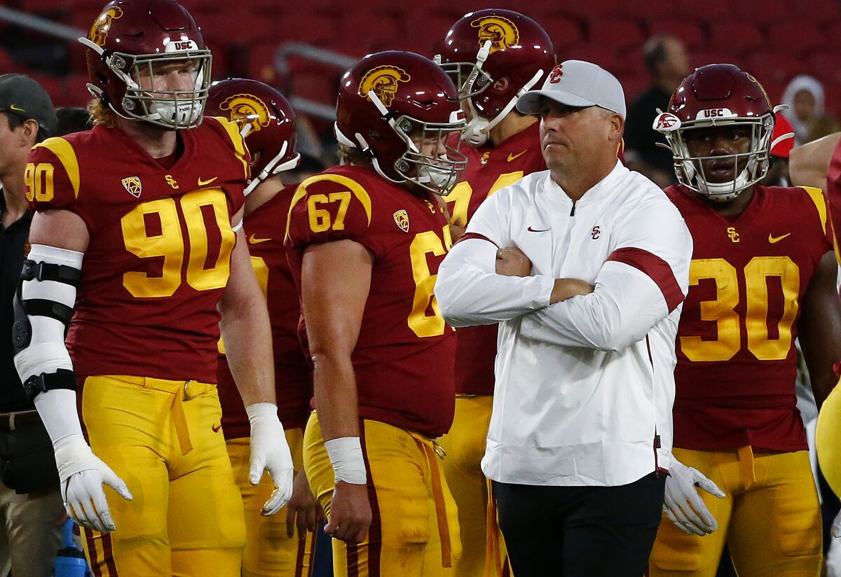 USC coach Clay Helton watches his team warm up before a game against Arizona at the Coliseum.