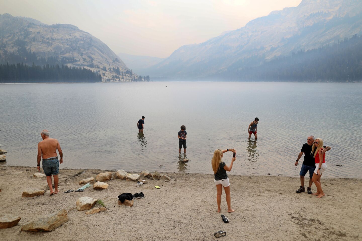 The Zutelman family of Buenos Aires wades in the Tenaya Lake as Yosemite National Park remains clouded in smoke from the Ferguson fire.