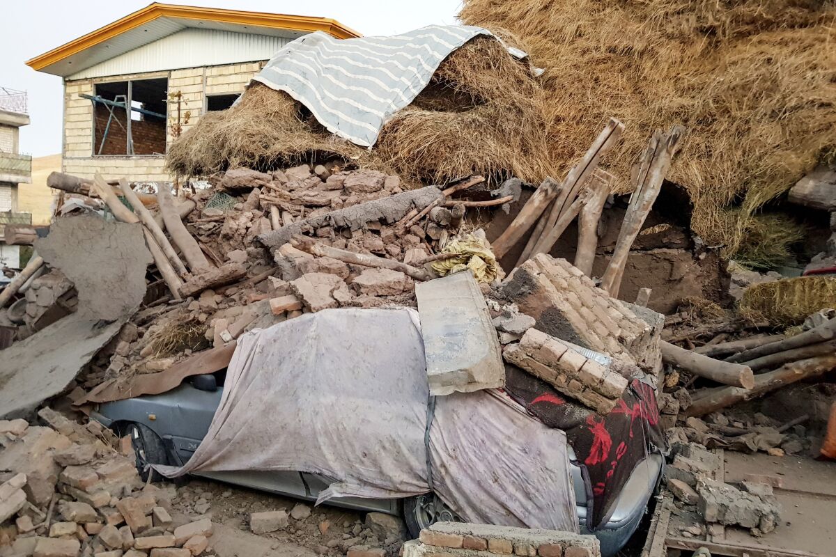 A car lays smashed by debris from an earthquake in Varankesh village in Eastern Azerbaijan province, some 250 miles (400 kilometers) northwest of the capital Tehran, Iran, Friday, Nov. 8, 2019. The temblor struck Tark county in Iran's Eastern Azerbaijan province early Friday. (Mohammad Zinali/Tasnim News Agency via AP)