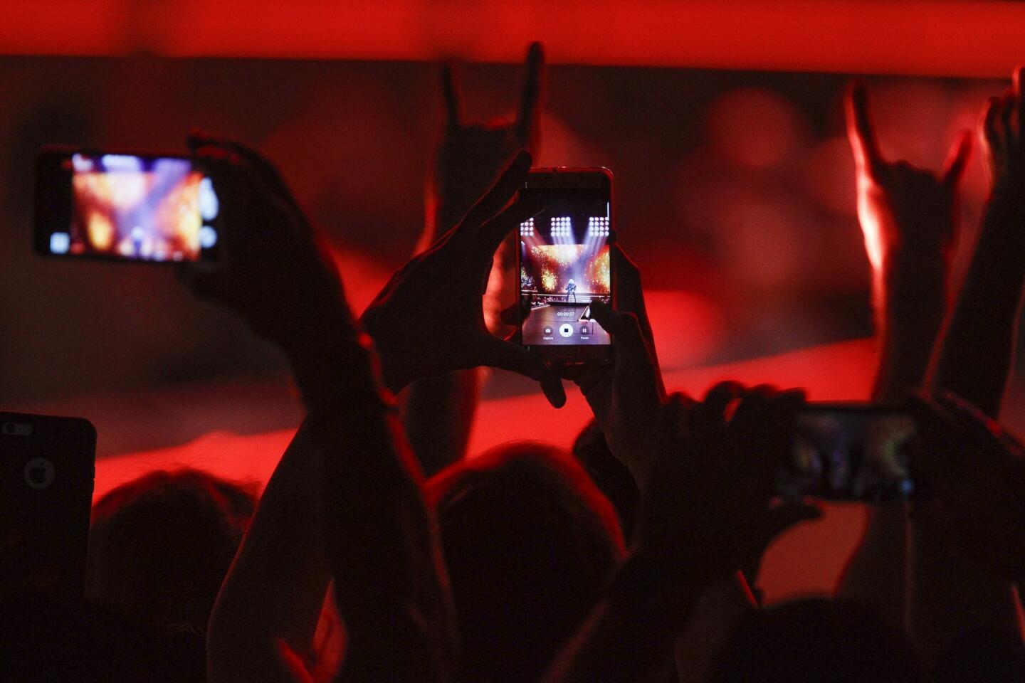 Fans record Madonna on their phones as she performs.