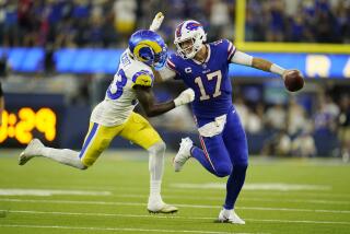 Buffalo Bills quarterback Josh Allen (17) stiff-arms Los Angeles Rams safety Nick Scott.