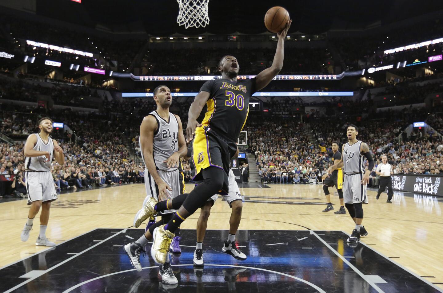 Los Angeles Lakers forward Julius Randle (30) shoots past San Antonio Spurs center Tim Duncan (21) during the first half on Friday.