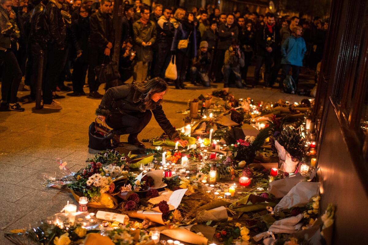 A mourner leaves candles in front of the Le Carillon restaurant Nov. 14 in Paris, honoring victims of the previous night's terrorist attacks.