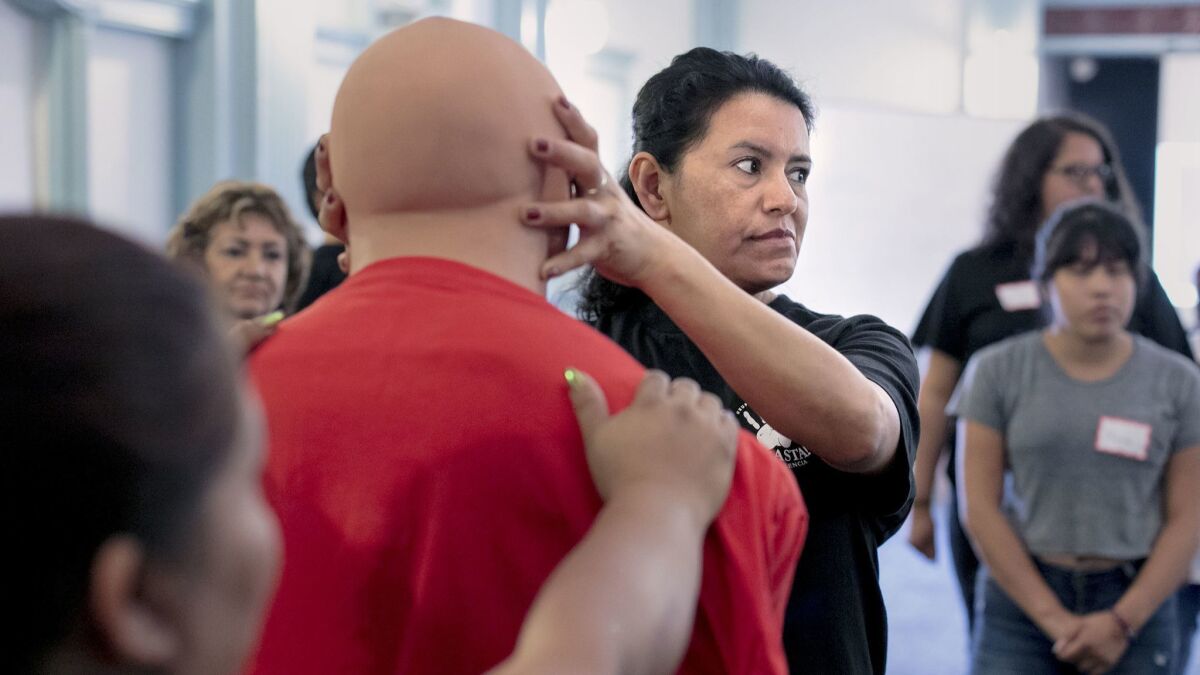 Maria Nieto, 42, demonstrates an eye gouge on a male mannequin during a self-defense training session for janitors at the Maintenance Cooperation Trust Fund building in downtown Los Angeles.